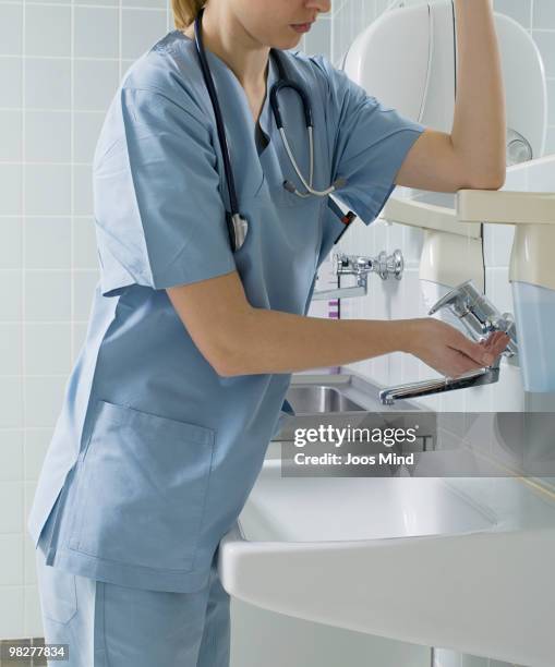 nurse sanitizing hands in hospital - nurse washing hands stock pictures, royalty-free photos & images