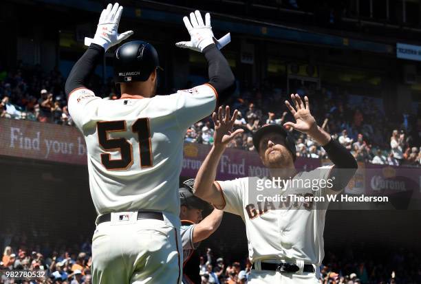 Mac Williamson and Hunter Pence of the San Francisco Giants celebrates after they both score against the Miami Marlins in the bottom of the six...