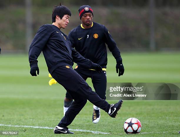 Ji-Sung Park of Manchester United passes the ball past Patrice Evra during a training session ahead of their Champions League match against Bayern...