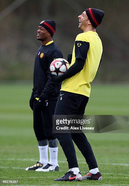 Rio ferdinand and Patrice Evra of Manchester United share a joke during a training session ahead of their Champions League match against Bayern...
