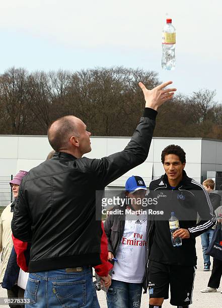 Unknown man throws up a bottle in front of Paolo Guerrero after the Hamburger SV training session at the HSH Nordbank Arena on April 6, 2010 in...