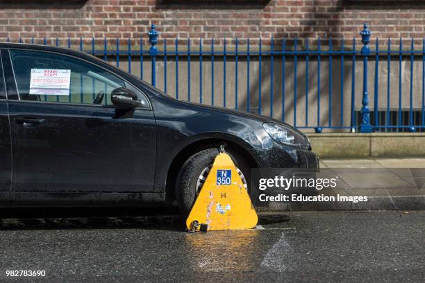 Car clamped with wheel clamp in Dublin city center, Republic of Ireland.