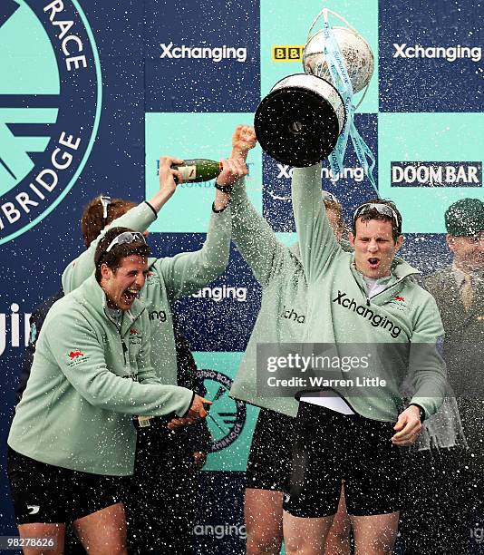 Deaglan McEachern, President of Cambridge holds the trophy as team mates celebrate victory after the 156th Oxford and Cambridge University Boat Race...