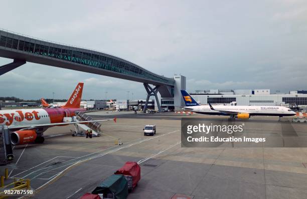 London Gatwick Airport, Surrey, UK Passenger airbridge, planes pass below and passengers cross from terminals above ground.