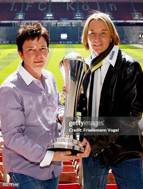 Head coach Martina Voss-Tecklenburg of FCR 2001 Duisburg and head coach Heidi Vater of FF USV Jena pose with the trophy before the DFB press...