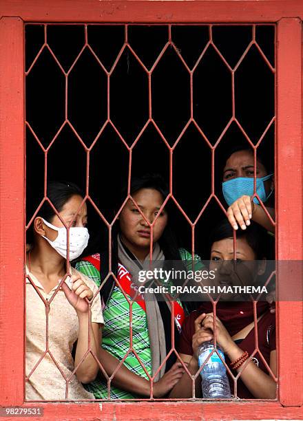 Unified Communist Party of Nepal supporter watch from a window as unseen Party Chairman Pushpa Kamal Dahal, also known as 'Prachanda', addresses a...