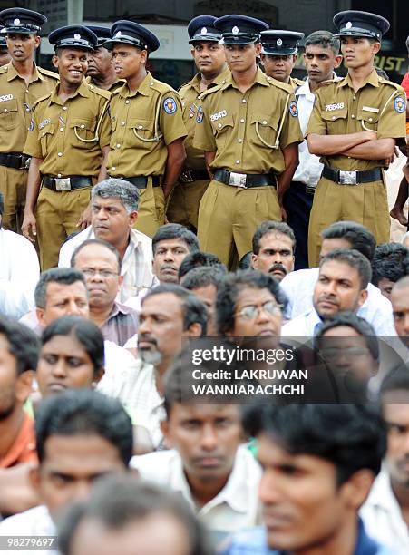 Police stand guard as a group of Sri Lankan protestors call for the release of detained former army chief General Sarath Fonseka in Colombo April 6...