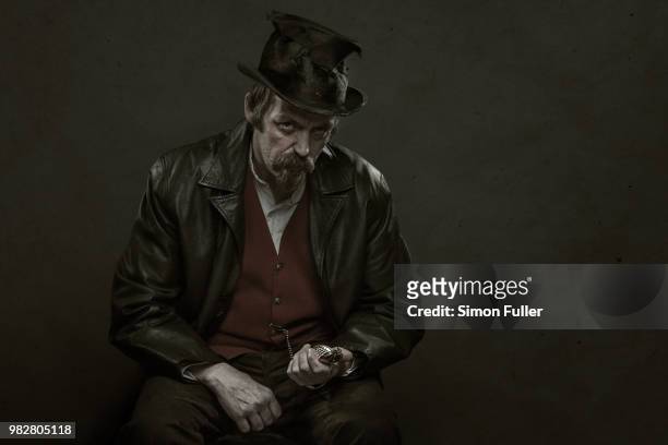 portrait of man in black leather jacket and hat holding pocket watch - contact list stock-fotos und bilder
