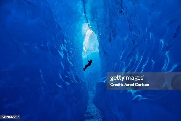 climber rappelling into cave - espeleología fotografías e imágenes de stock