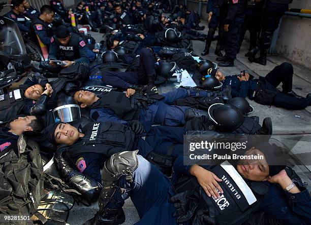 Riot Police rest near a shopping center as thousands of Red shirt supporters of former PM Thaksin Shinawatra defy the government for a fourth day by...