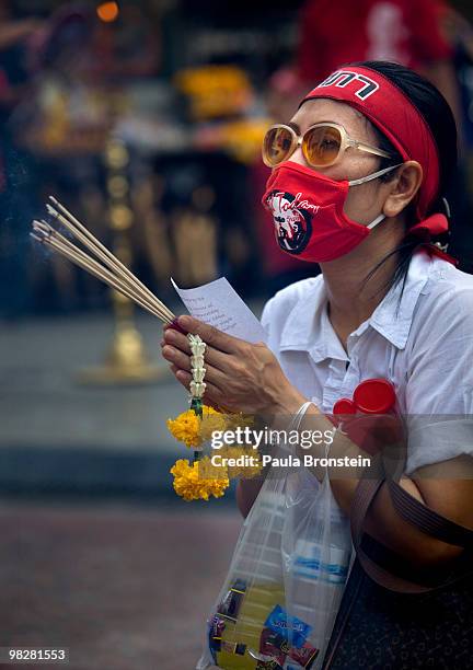 Protester prays at a buddhist shrine as thousands of Red shirt supporters of former PM Thaksin Shinawatra defy the government for a fourth day by...