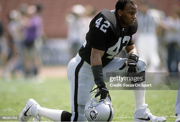 Defensive Back Ronnie Lott of the Los Angeles Raiders kneeling on the field watching his team warm-up September 15, 1991 before an NFL football game...
