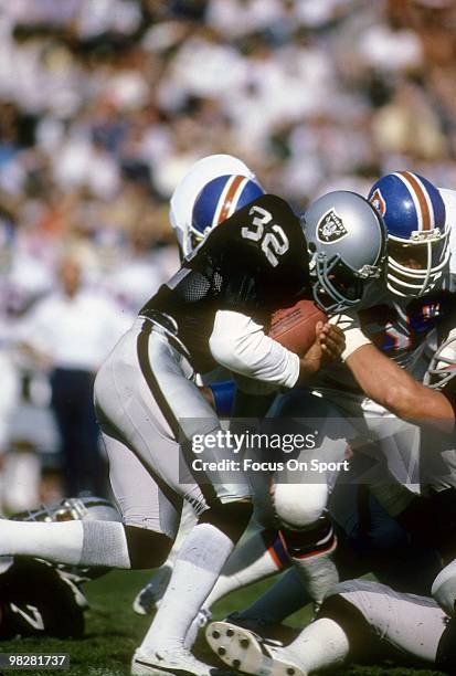 Running Back Marcus Allen of the Los Angeles Raiders plays carries the ball against the Denver Broncos circa mid 1980's during an NFL Football game...