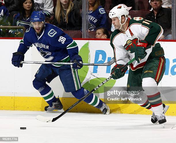 Pavol Demitra of the Vancouver Canucks looks on as Owen Nolan of the Minnesota Wild skates up ice with the puck during their game at General Motors...