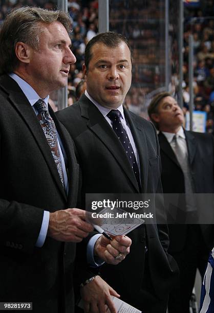 Associate coach Rick Bowness litens to head coach Alain Vigneault of the Vancouver Canucks during their game against the Minnesota Wild at General...