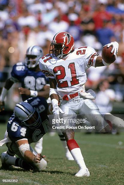 Defensive back Dion Sanders of the Atlanta Falcons plays carrying the ball avoiding the tackle of centre Tom Rafferty of the Dallas Cowboys September...