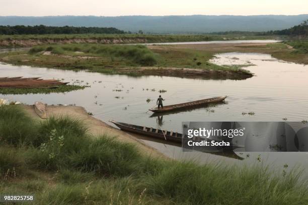 nepalese local man traveling by boat on a rapti river in a national park chitwan - chitwan stock pictures, royalty-free photos & images
