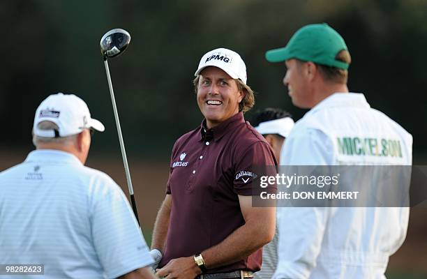 Phil Mickelson laughs with his caddy on the practice range at the Masters golf tournament at Augusta National Golf Club April 6, 2010 in Augusta,...