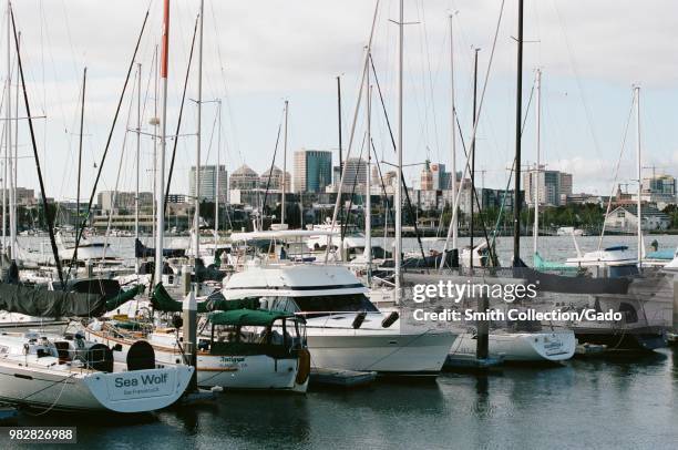 Sailboats and motorboats are visible in Alameda Marina, with the urban skyline of Oakland, California visible in the background, Alameda Island,...