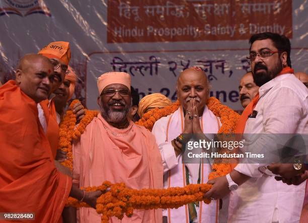 Former Vishwa Hindu Parishad leader Pravin Togadia is presented a garland by other leaders during the launch of his new outfit International Hindu...
