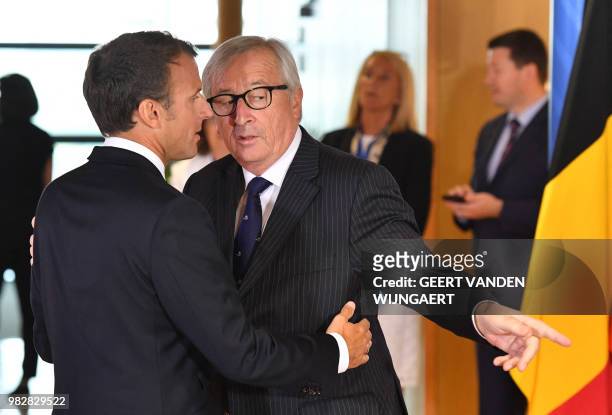 European Commission President Jean-Claude Juncker speaks with French President Emmanuel Macron during an informal EU summit on migration issues at EU...