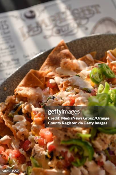 Lobster Nachos - warm lobster and house-made tortilla chips with black beans, pico de Gallo, chipotle crema, aged cheddar and Oaxaca cheese sauce at...