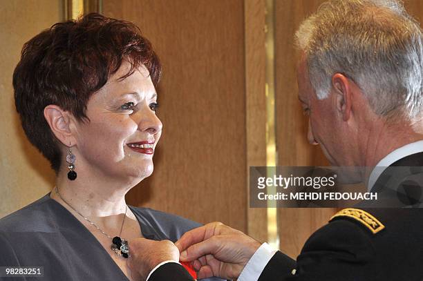 Canada's singer Fabienne Thibeault is awarded as Knight in order of Honor on March 30, 2010 in Paris, by head of French Gendarmes, Roland Gilles. AFP...