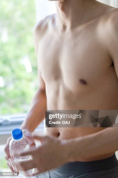 young man in underwear holding plastic bottle - seminua imagens e fotografias de stock