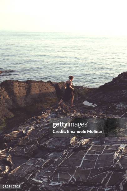 woman running in summer dress on seashore, sori, liguria, italy - mar de liguria fotografías e imágenes de stock