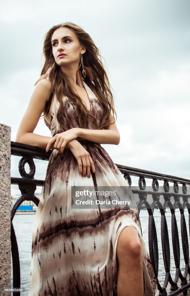 Portrait of beautiful young lady on the background of the river