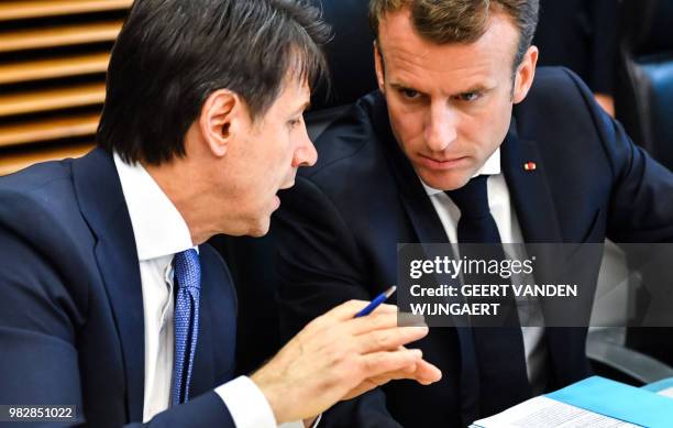 French President Emmanuel Macron speaks with Italian Prime Minister Giuseppe Conte during a round table meeting at an informal EU summit on migration...