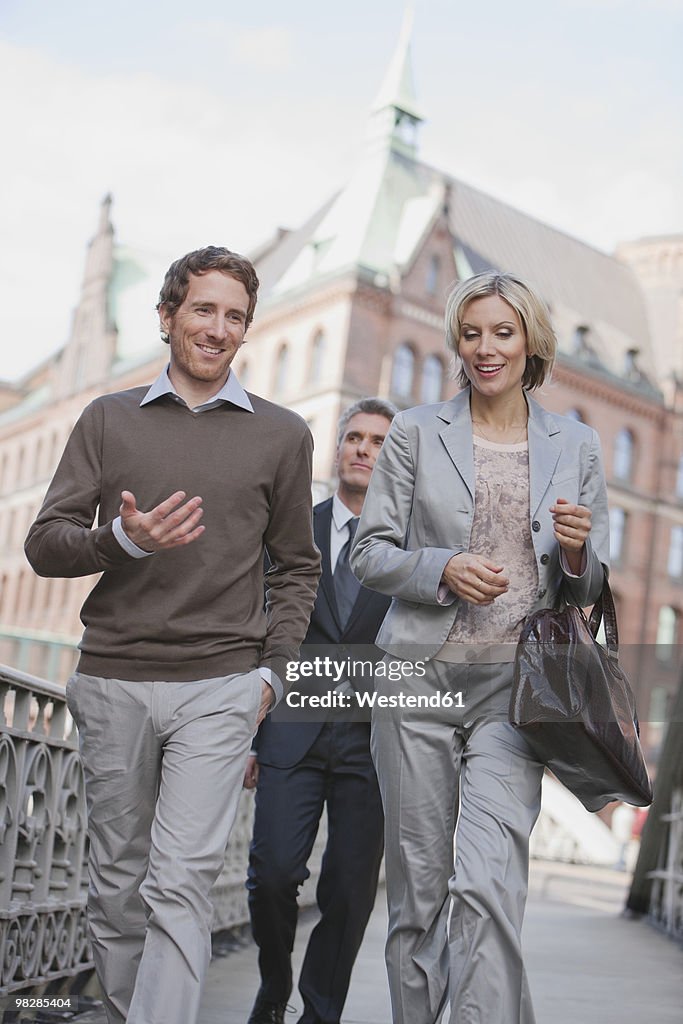 Germany, Hamburg, Three Business people crossing bridge