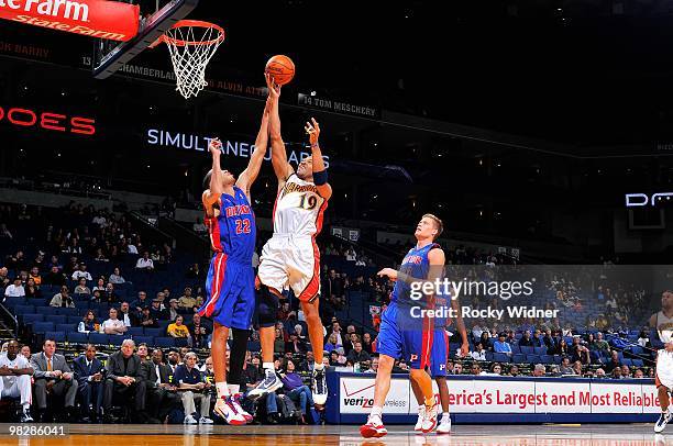 Devean George of the Golden State Warriors lays the ball up over Tayshaun Prince and Jonas Jerebko of the Detroit Pistons during the game on February...