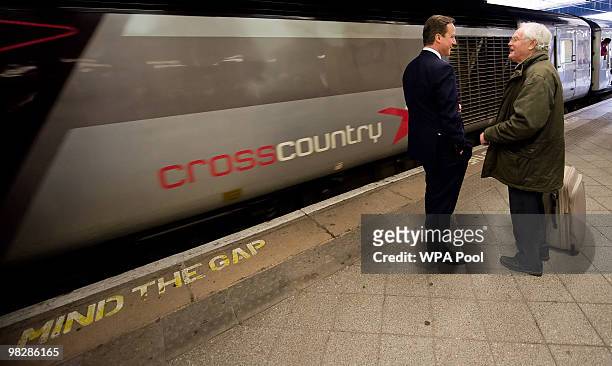 British Opposition Conservative Party leader David Cameron speaks to a member of the public as he waits for a train at Birmingham New Street rail...