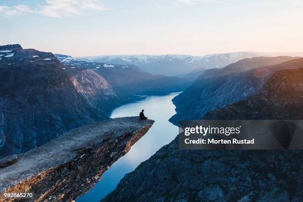man sitting on rock edge above river, hardangerfjord, hordaland, norway - hardangerfjord ストックフォトと画像