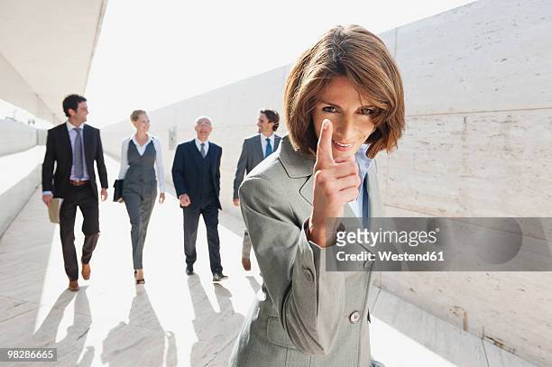 spain, mallorca, businesswoman gesturing, business people in background - portrait man suit smiling light background stock pictures, royalty-free photos & images