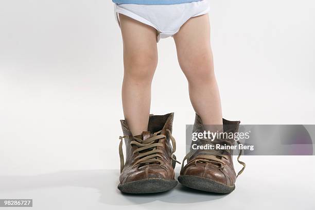 child wearing big shoes, low section - surdimensionné photos et images de collection