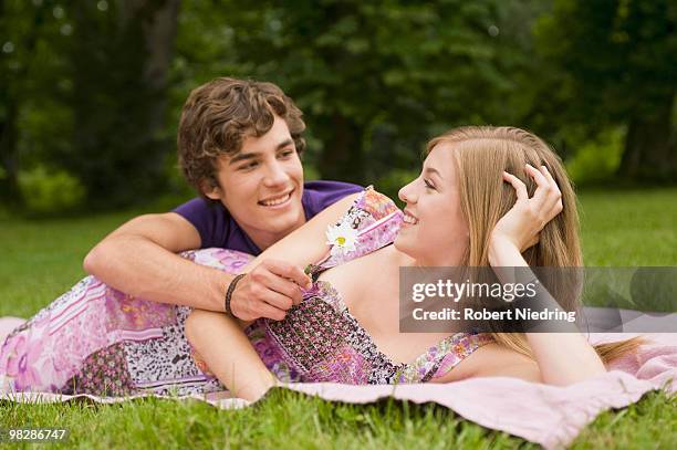 germany, bavaria, starnberger see, young xouple lying in meadow, young man giving woman flower - man giving flowers stock-fotos und bilder