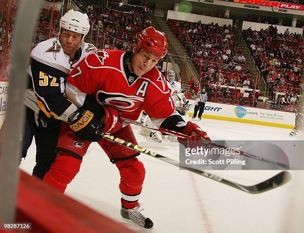 Rod Brind'Amour Carolina Hurricanes battles along the boards with Craig Rivet of the Buffalo Sabres during the NHL game on March 21, 2010 at the RBC...