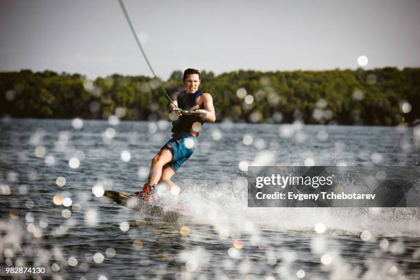 young man wakeboarding, lake simcoe, ontario, canada - waterskiing stock pictures, royalty-free photos & images