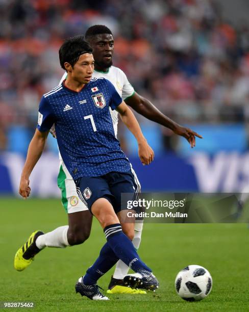 Gaku Shibasaki of Japan passe the ball under pressure from Alfred Ndiaye of Senegal during the 2018 FIFA World Cup Russia group H match between Japan...