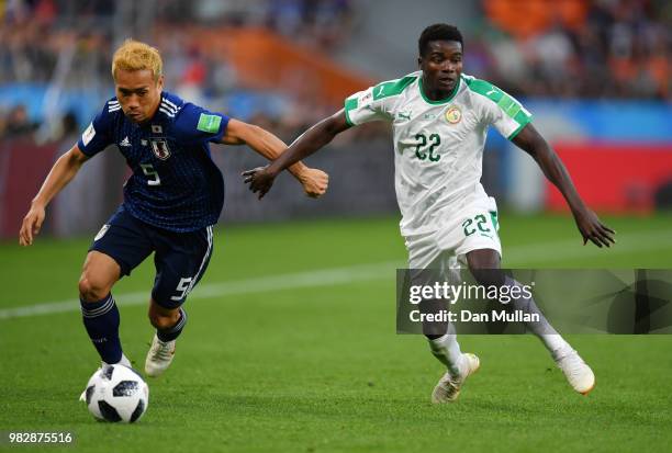 Yuto Nagatomo of Japan runs with the ball under pressure from Moussa Wague of Senegal during the 2018 FIFA World Cup Russia group H match between...