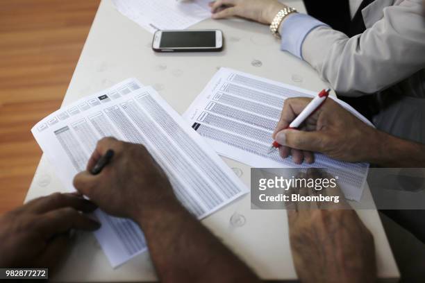 Electoral officials mark papers during a ballot count following voting in the parliamentary and presidential elections in Istanbul, Turkey, on...