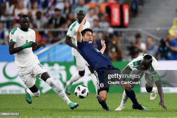 Shinji Kagawa of Japan is rought down by Sadio Mane of Senegal during the 2018 FIFA World Cup Russia group H match between Japan and Senegal at...