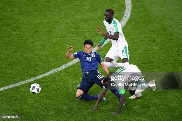 Shinji Kagawa of Japan is rought down by Sadio Mane of Senegal during the 2018 FIFA World Cup Russia group H match between Japan and Senegal at...