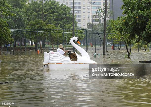 Man pedals a swan paddle boat in a flooded parking lott in front of the Rio de Janeiro's landmark Rodrigo de Freitas lagoon Rio de Janeiro, on April...