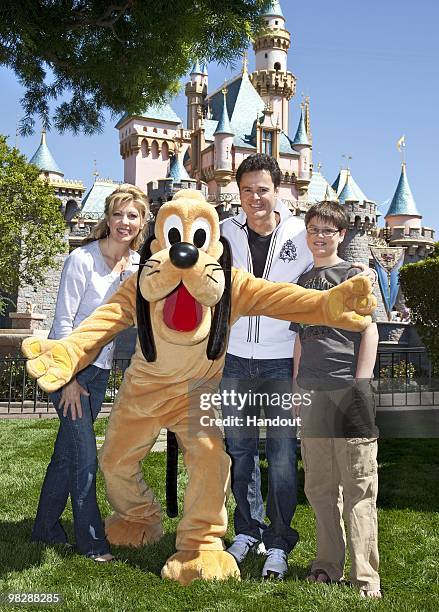 In this handout photo provided by Disney, entertainer Donny Osmond, wife Debbie and son Joshua meet Pluto at Disneyland on April 4, 2010 in Anaheim,...