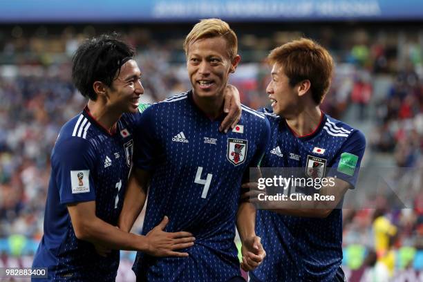 Keisuke Honda of Japan celebrates with teammates Yuya Osako and Gaku Shibasaki after scoring his team's second goal during the 2018 FIFA World Cup...