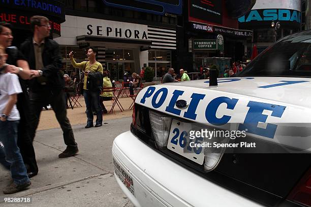People walk by a New York City Police Department vehicle on April 6, 2010 in Times Square in New York City. Following a melee involving groups of...