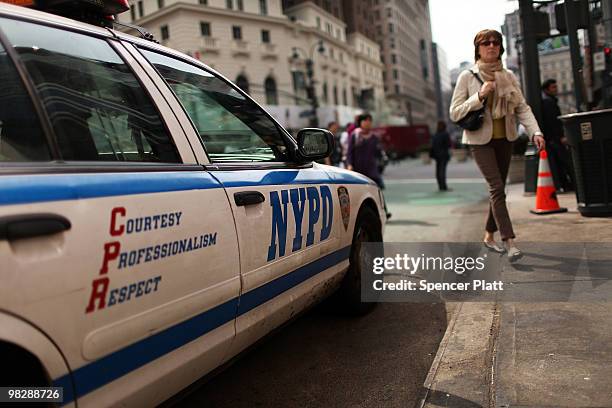 Woman walks by a New York City Police Department vehicle on April 6, 2010 in New York City. Following a melee involving groups of youths around Times...